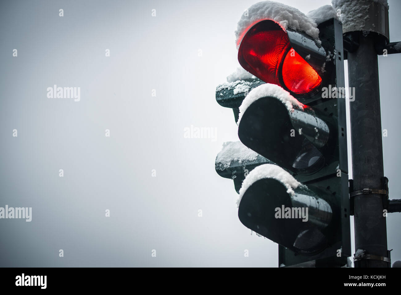 Luce di traffico in inverno con neve rosso Foto Stock