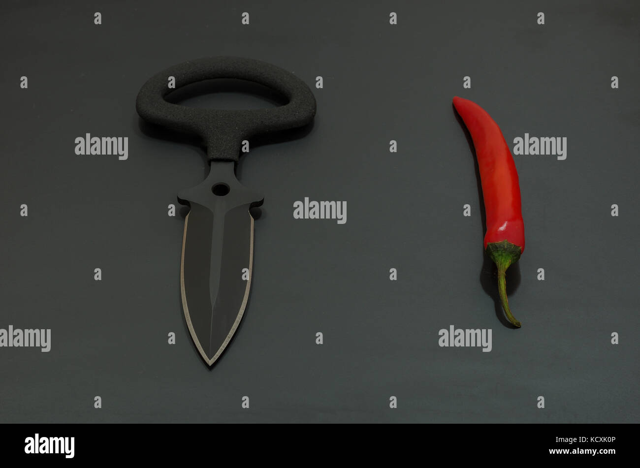 Sharp coltello a baionetta per attacco. Coltello nero e pepe rosso. Foto Stock