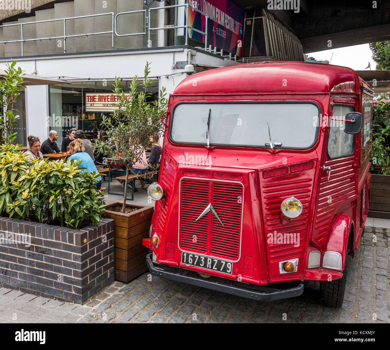 Un vintage Citroen H furgone lamierato, dipinte di rosso e parcheggiata al di fuori di un bar / ristorante sulla South Bank di Londra, Inghilterra, Regno Unito. Foto Stock