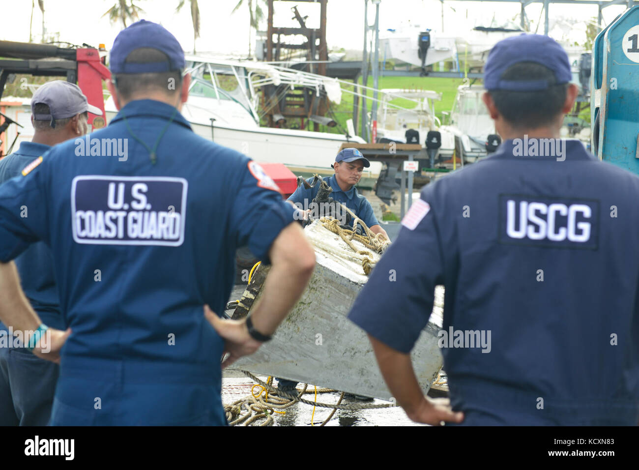 Coast Guard membri supervisiona il distacco di un serbatoio del gasolio dall'acqua a marina dopo il passaggio dell uragano Maria il 5 ottobre 2017 in Fajardo, Puerto Rico. La guardia costiera della risposta di inquinamento team stanno lavorando per ridurre l'inquinamento da navi che sono stati notificati come danneggiati o hanno affondato come risultato di uragano a Maria la forza. Stati Uniti Coast Guard foto di Sottufficiali di seconda classe Meredith Manning Foto Stock