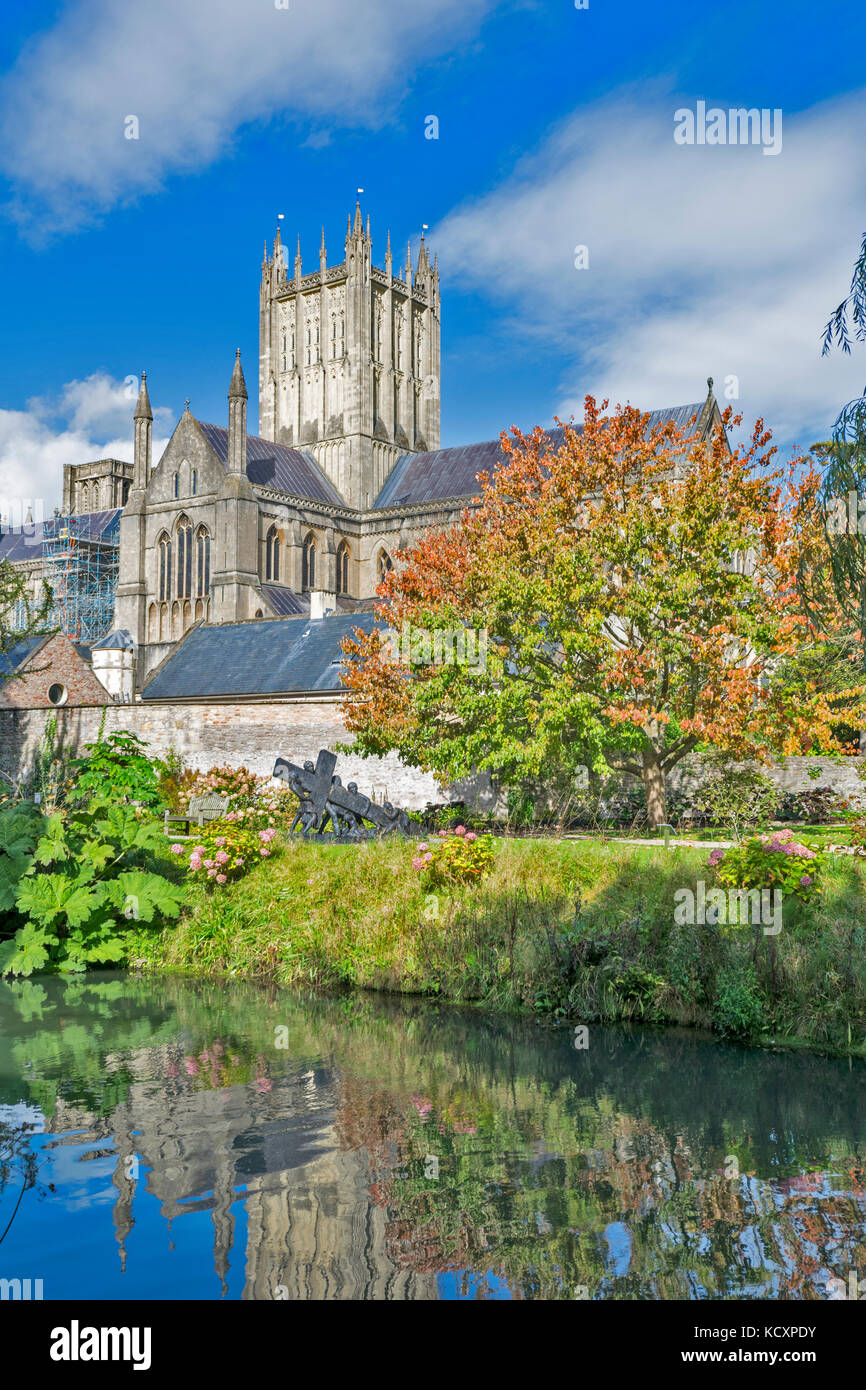 WELLS SOMERSET Inghilterra la cattedrale si riflette nell'acqua del fossato e albero con Red foglie autunnali Foto Stock