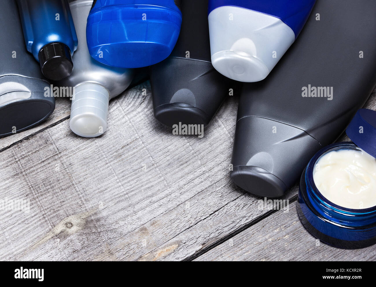 Gli uomini cosmetici da sfondo. varie cure del viso e del corpo prodotti cosmetici per uomo stabiliti come cornice semicircolare su vecchie tavole di legno. spazio copia Foto Stock