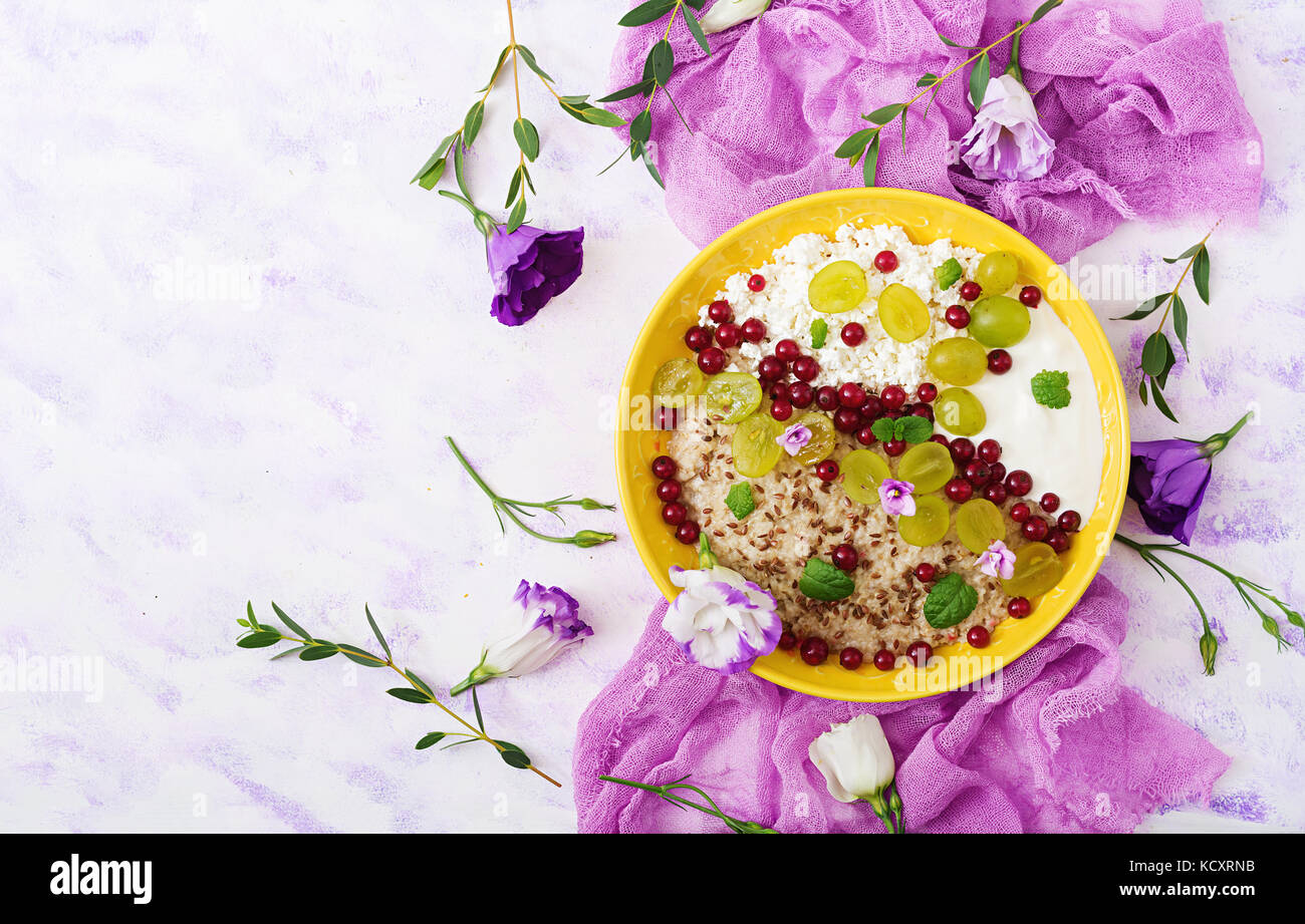 Delizioso e sano di farina di avena con uve, yogurt e formaggio. Colazione sana. fitness. alimentare nutrizione adeguata. flat laici. vista dall'alto. Foto Stock