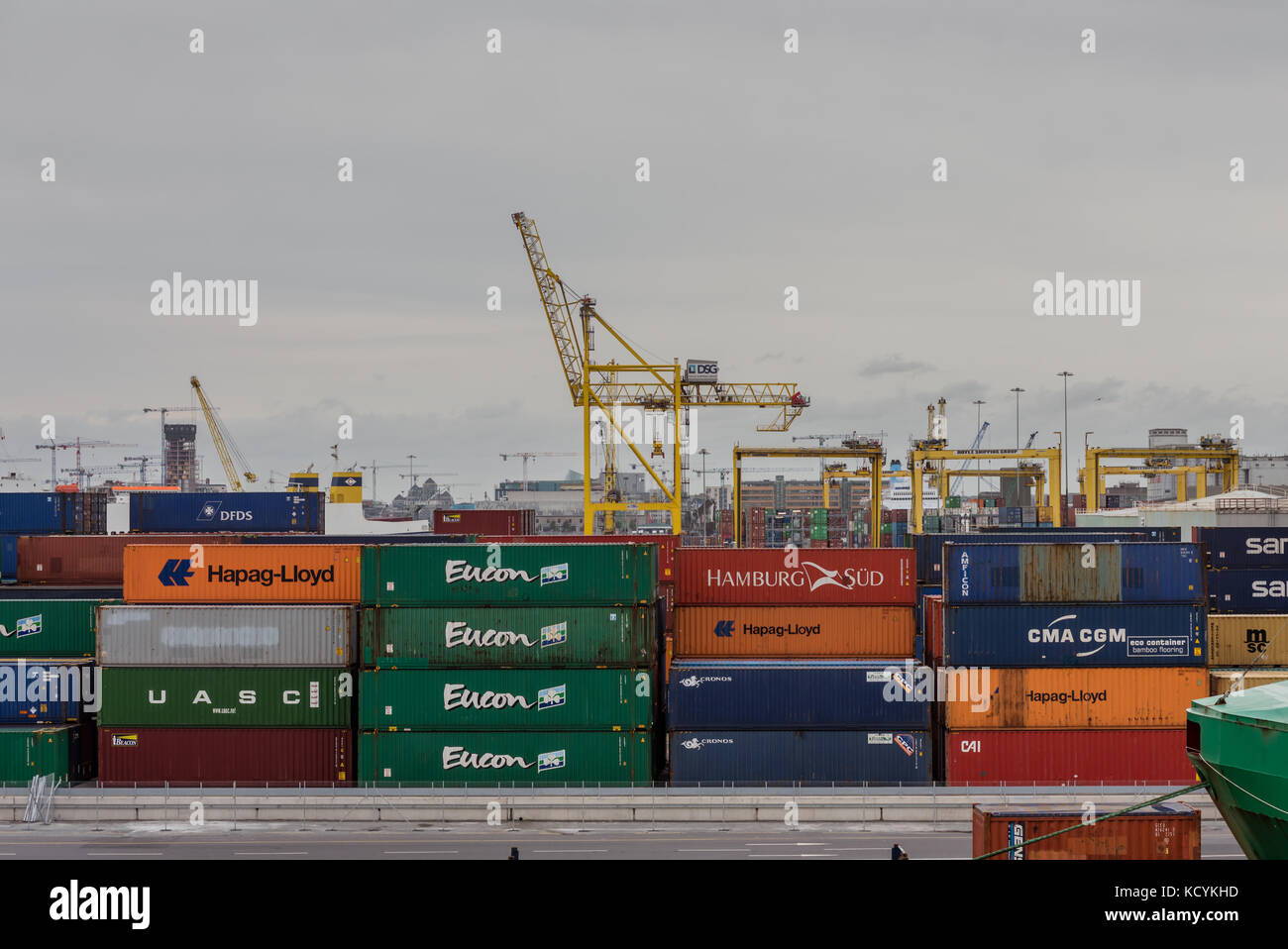 Esportare e importare merci in contenitori in attesa a Dublino docks con gru da carico in background. Foto Stock