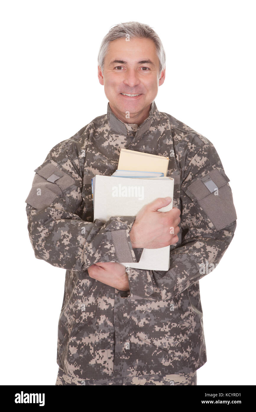 Coppia soldier holding pila di libri isolati su sfondo bianco Foto Stock