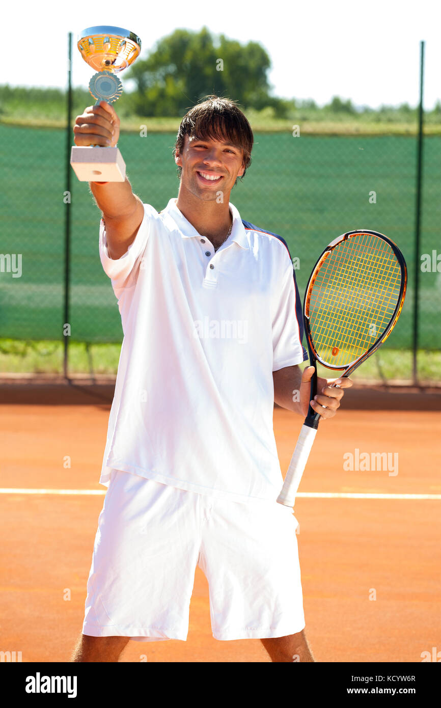 Sorridente tennis vincitore che mostra il suo golden calice Foto Stock