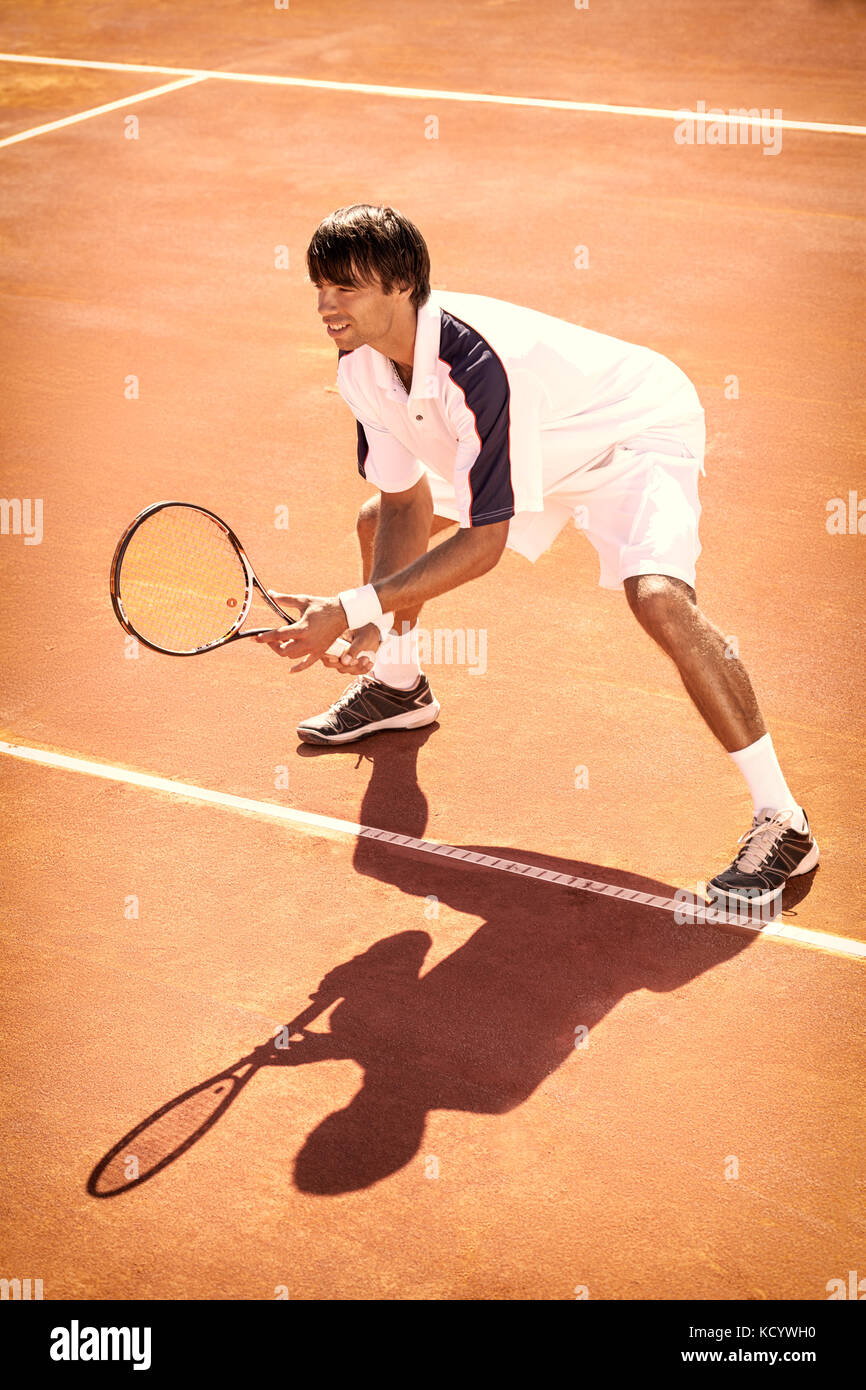 Lettore maschio presso il campo da tennis in terra battuta Foto Stock
