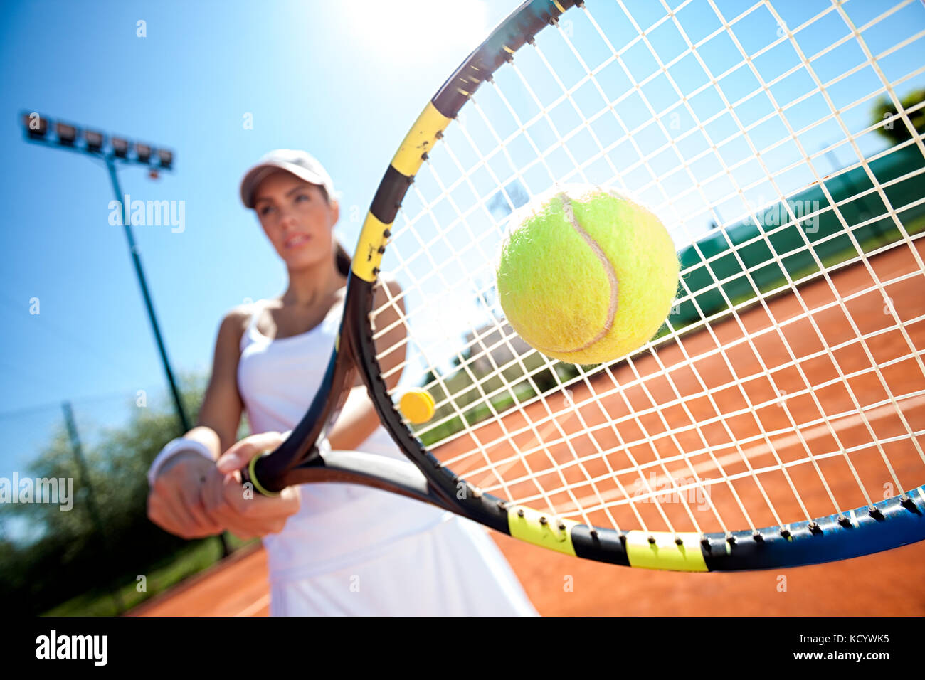 Giovane donna giocando a tennis in una giornata di sole Foto Stock