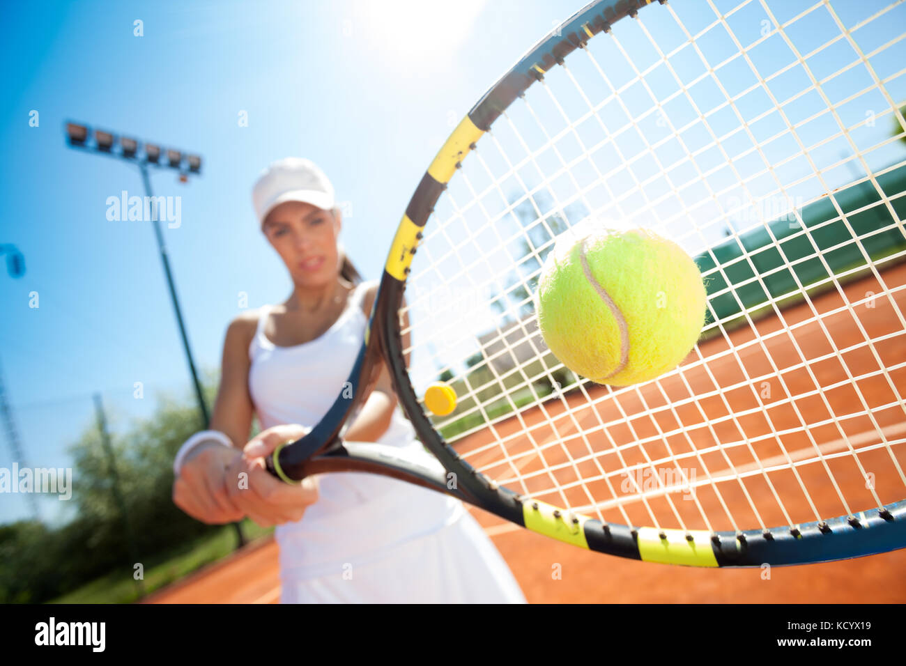 Giovane femmina sportivo giocatore di tennis di colpire la palla Foto Stock