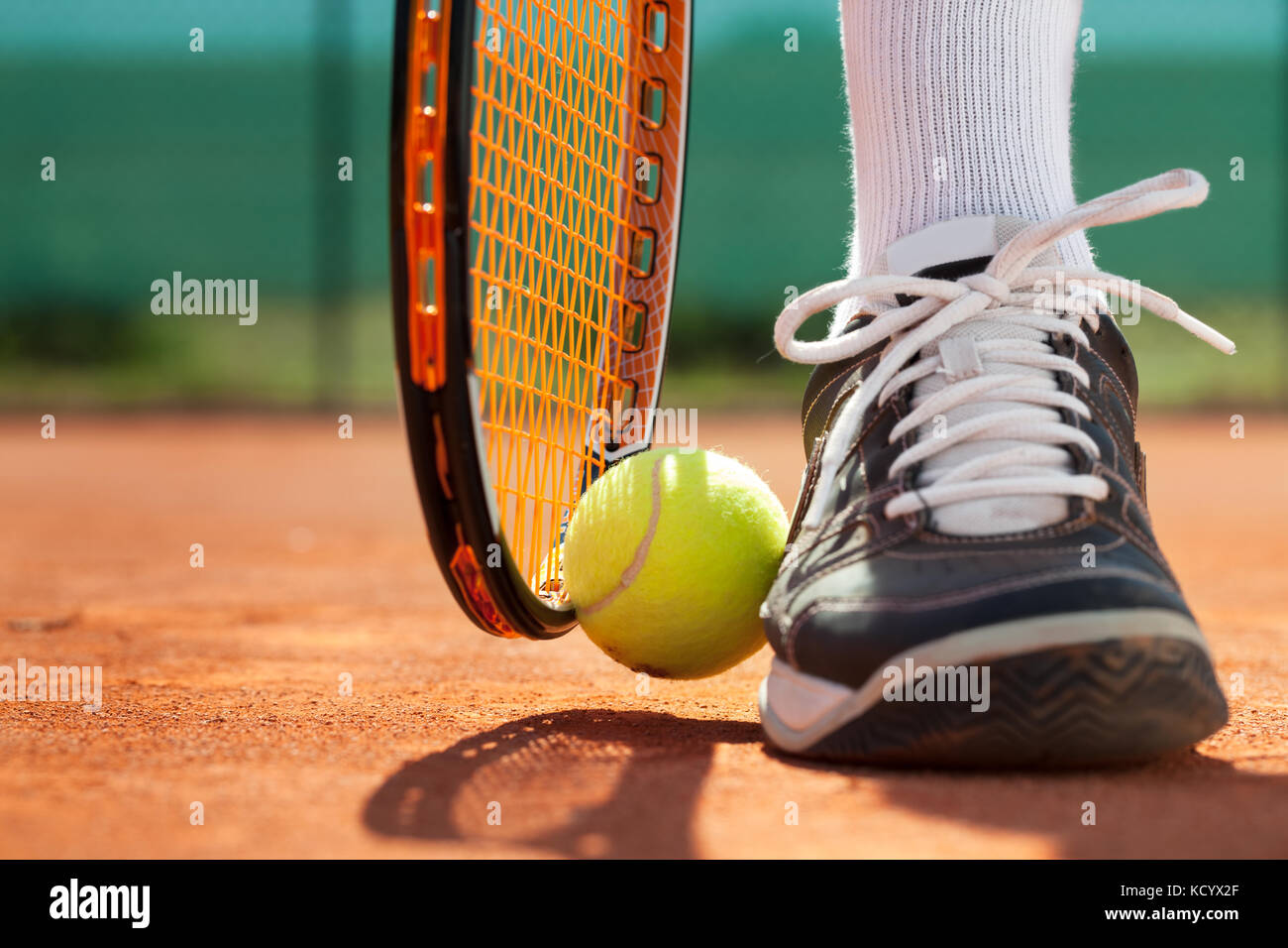 Gambe di uomo sportivo vicino la racchetta da tennis e sfere Foto Stock