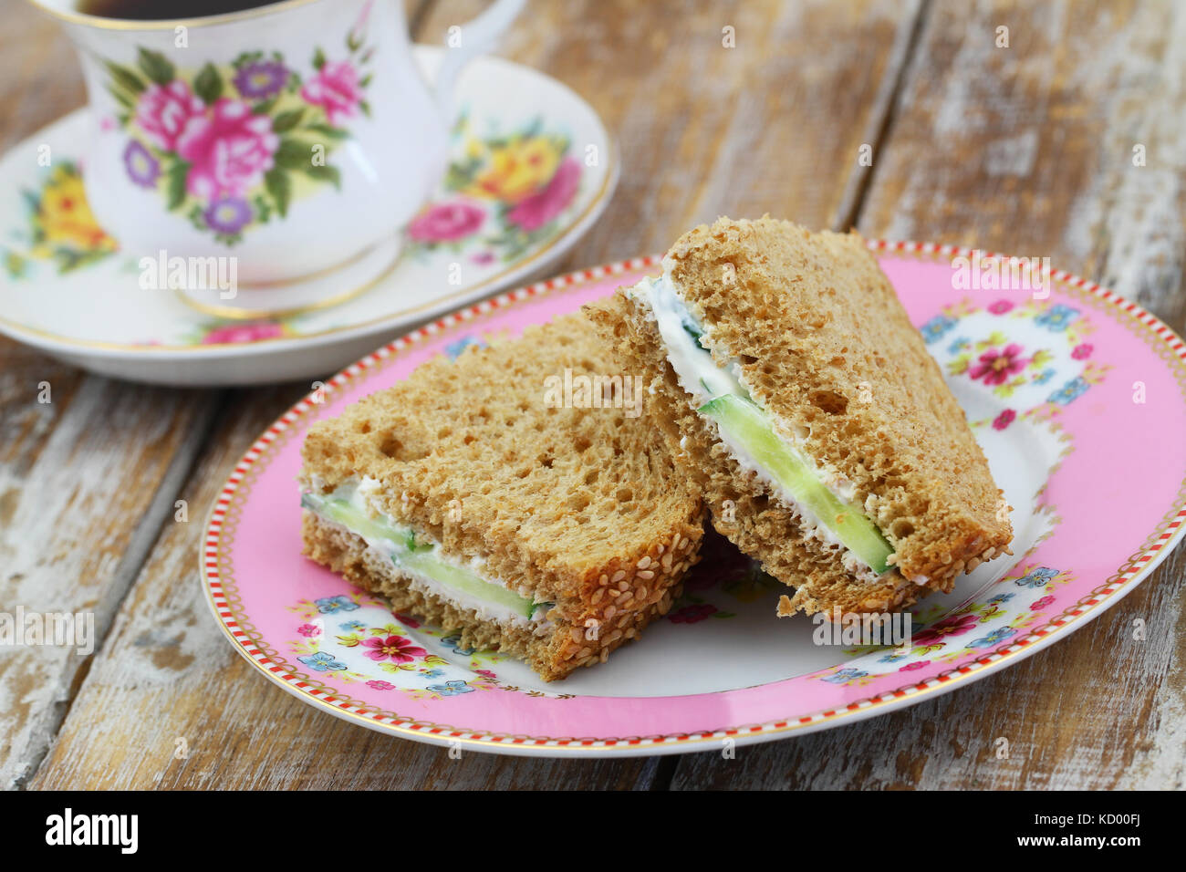 Pane marrone panini con la crema di formaggio sulla piastra colorata con la tazza di tè in tazza vintage Foto Stock