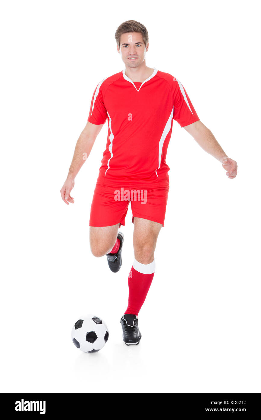 Giocatore di calcio calci calcio su sfondo bianco Foto Stock
