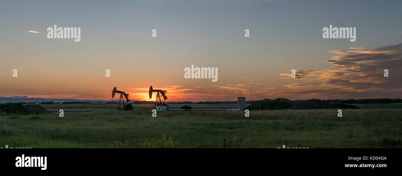 Pumpjack tramonto in montagna rocciosa pedemontana, rocky visualizza county, Alberta Foto Stock