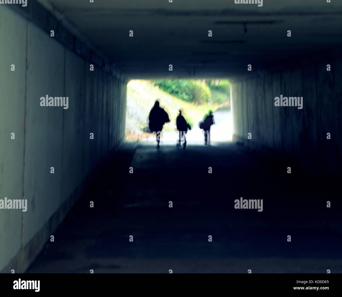 La famiglia in una galleria sottopassaggio direzione luce prospettiva silhouette madre e bambini Foto Stock