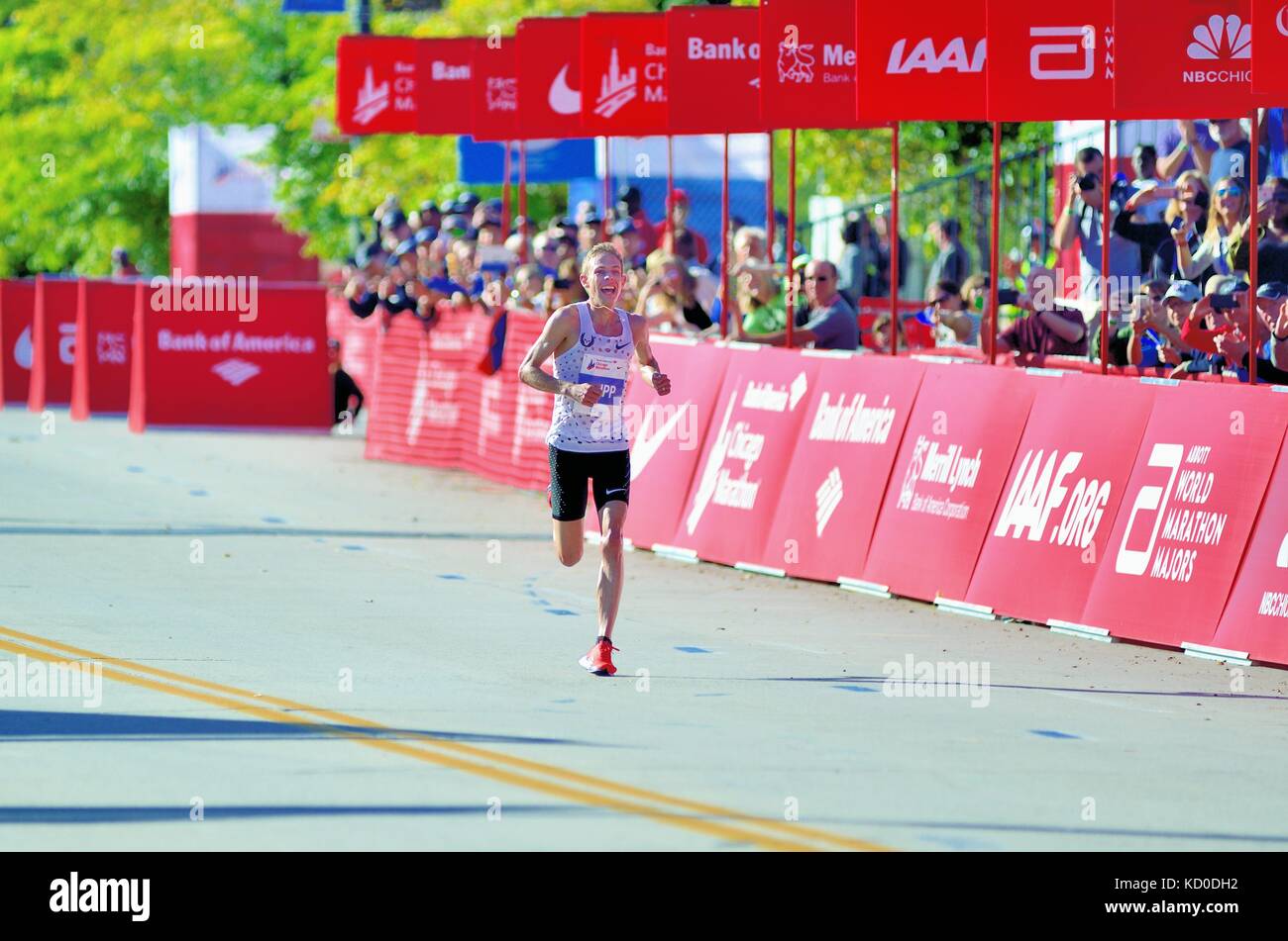 Un sorridente Galen Rupp, tutto solo nel tratto iniziale a pochi istanti dal traguardo e vincendo il 2017 Maratona di Chicago. Chicago, Illinois, Stati Uniti d'America. Foto Stock