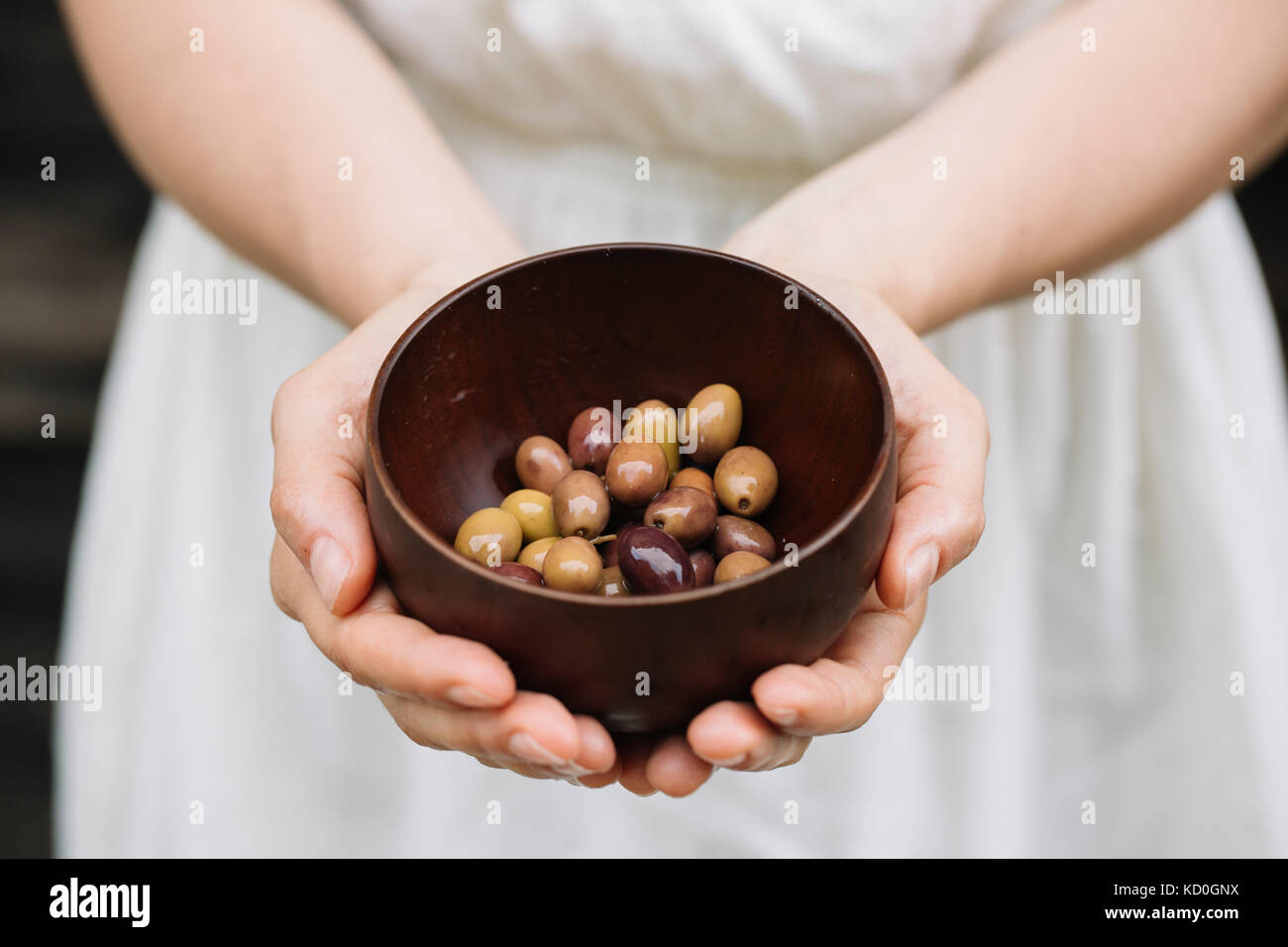 Donna che mantiene una ciotola di olive, metà sezione Foto Stock