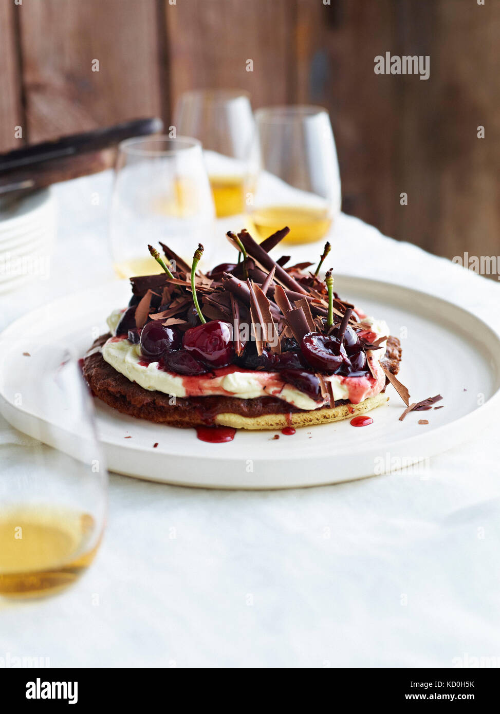 Base per pizza con la foresta nera fondente di cioccolato topping, sulla piastra bianca Foto Stock