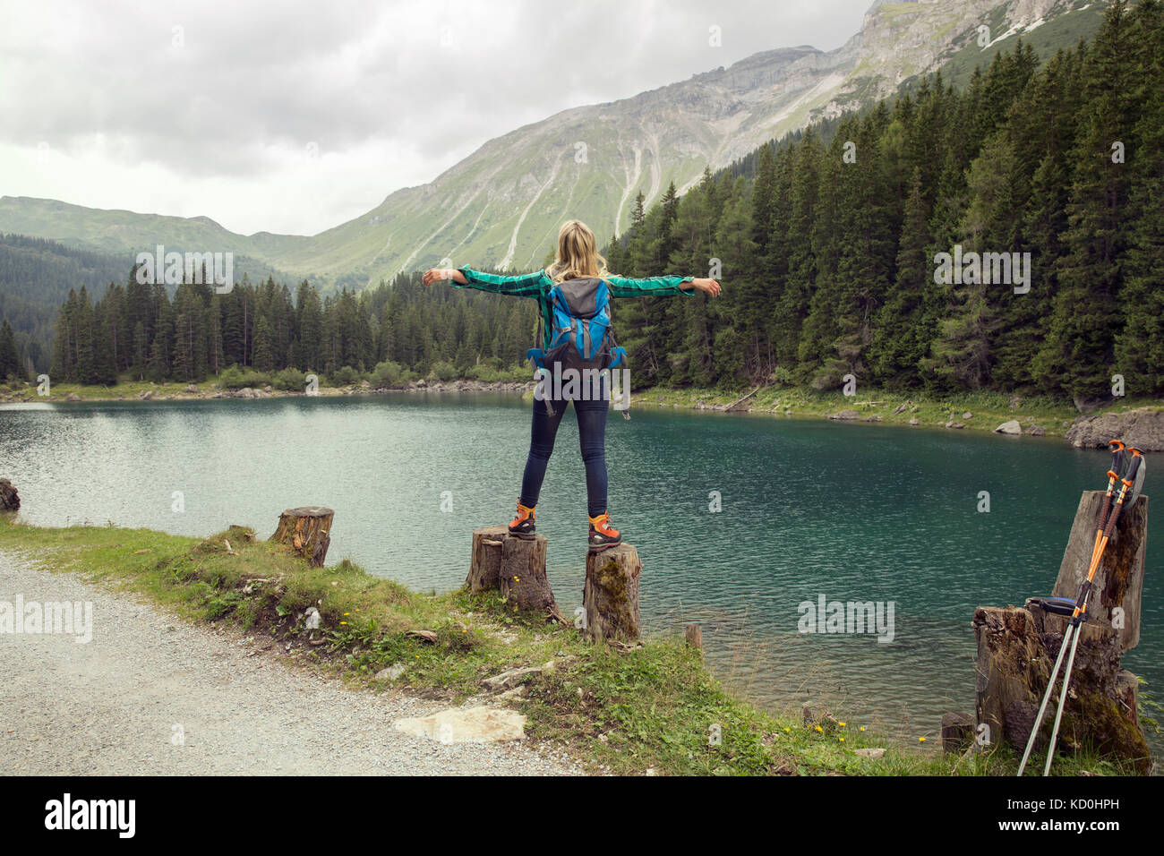 Vista posteriore della donna in equilibrio su rocce dal lago, tirol, Steiermark Austria, Europa Foto Stock