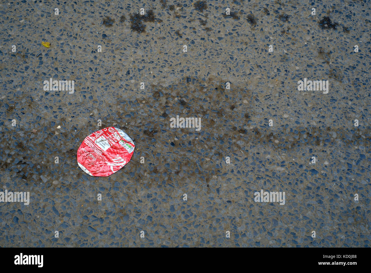 Vuoto appiattito coca cola può appiattito contro la strada asfaltata England Regno Unito Foto Stock