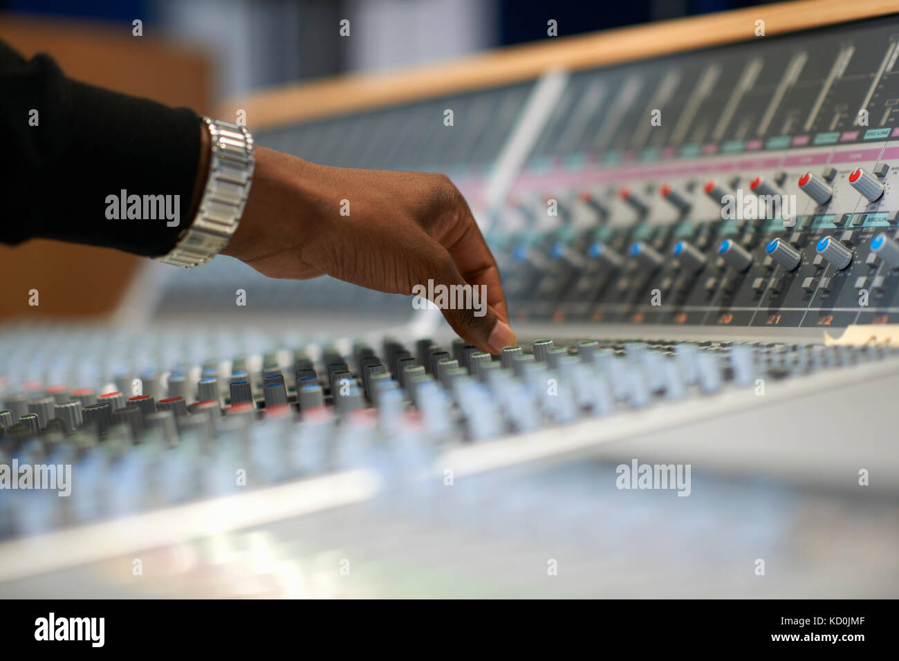 Mano del collegio maschile studente al mixer audio in studio di registrazione Foto Stock