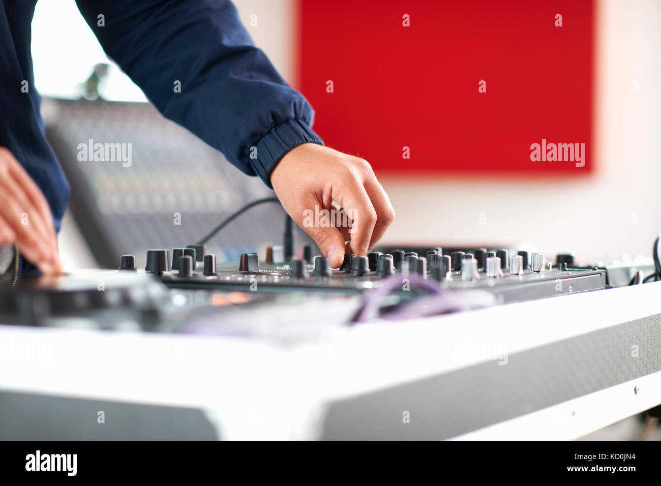 Le mani del collegio maschile dj studente di musica di regolazione sulla console di mixaggio Foto Stock