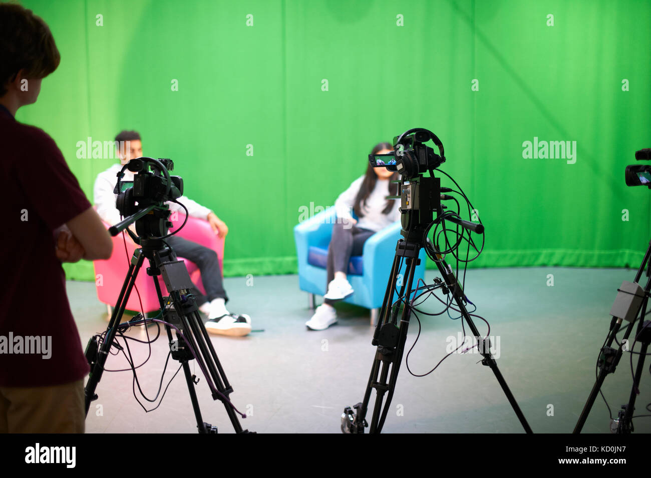 Giovane maschio e femmina studenti praticanti in studio tv con schermo verde Foto Stock