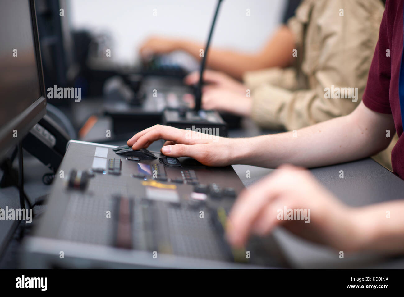 Le mani di maschio e femmina studenti del college a miscelazione a scrivania in studio TV Foto Stock