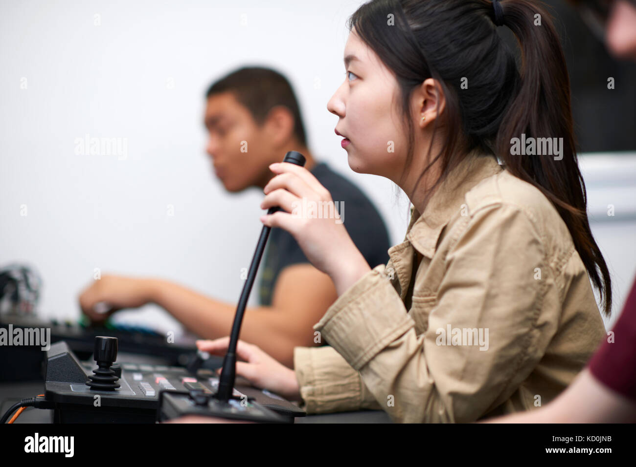 Giovane maschio e femmina studenti del college a miscelazione a scrivania in studio tv Foto Stock