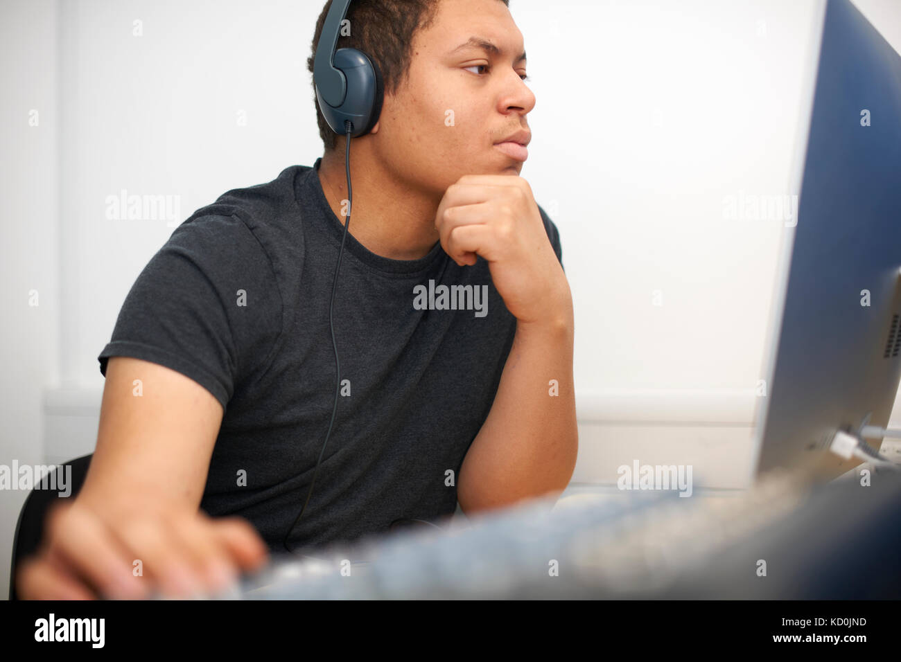 Maschio giovane studente di college a miscelazione a scrivania in studio tv Foto Stock