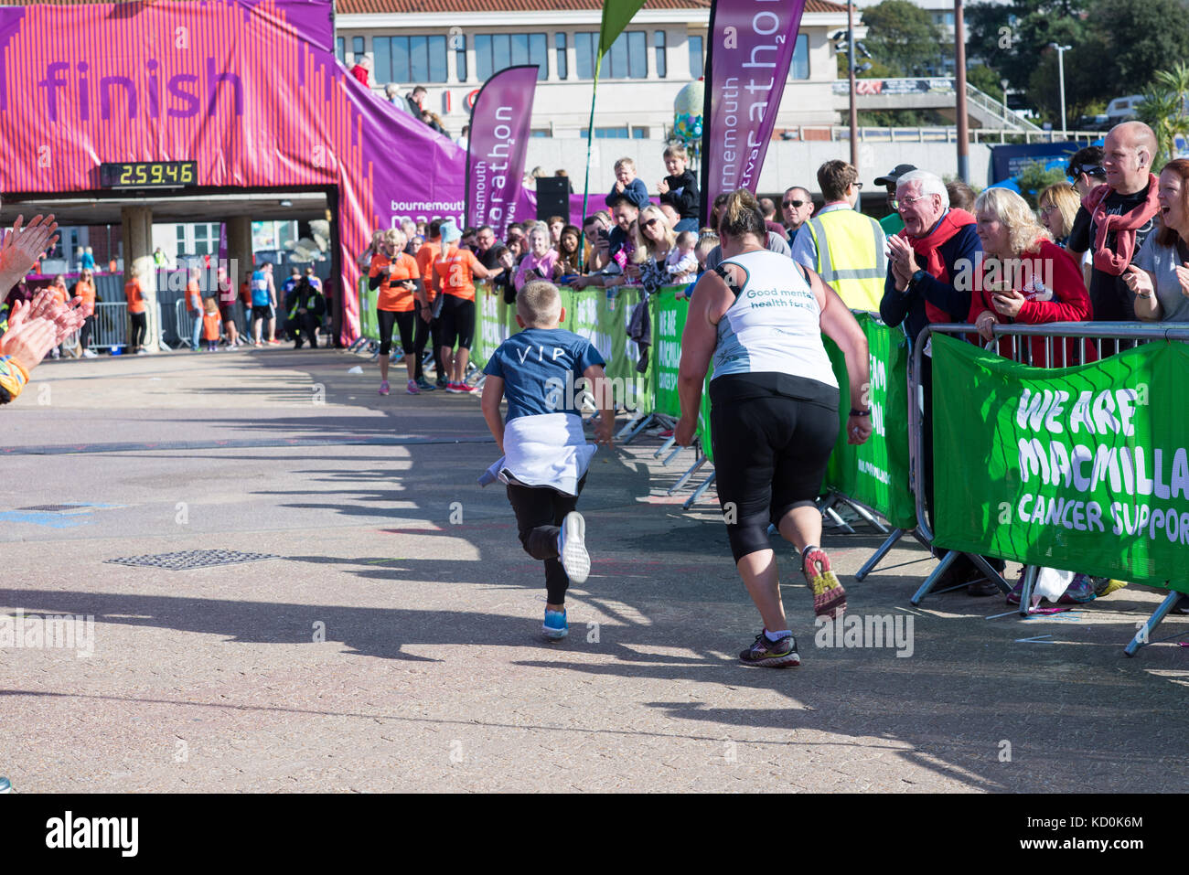 Bournemouth, Dorset, Regno Unito, 8th ottobre 2017. I corridori che gareggiano al festival della maratona di Bournemouth. Una donna e un bambino che corre per il traguardo. Foto Stock