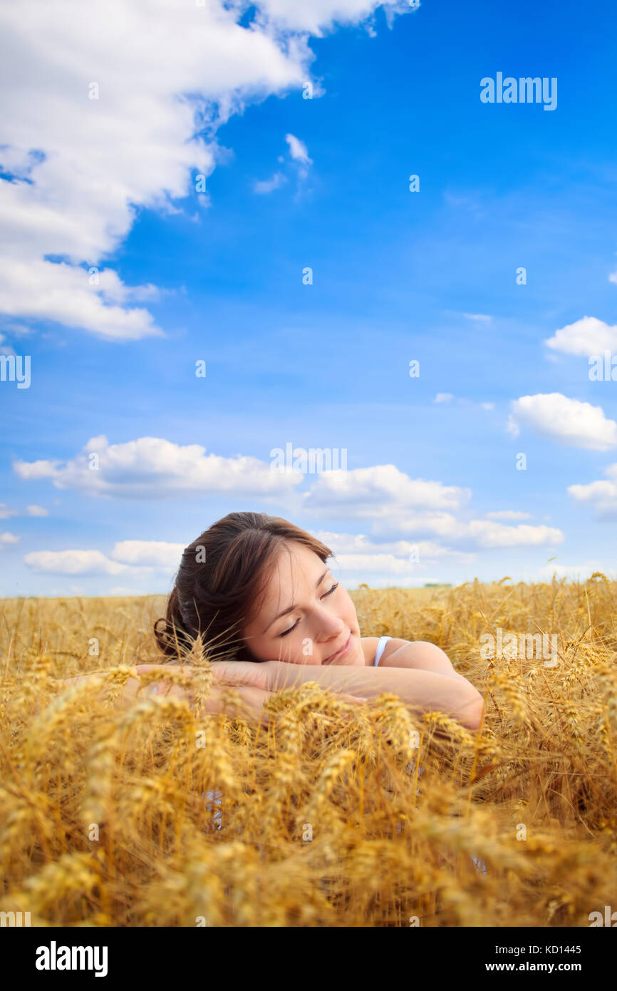Giovane donna graziosa su giallo campo di grano Foto Stock
