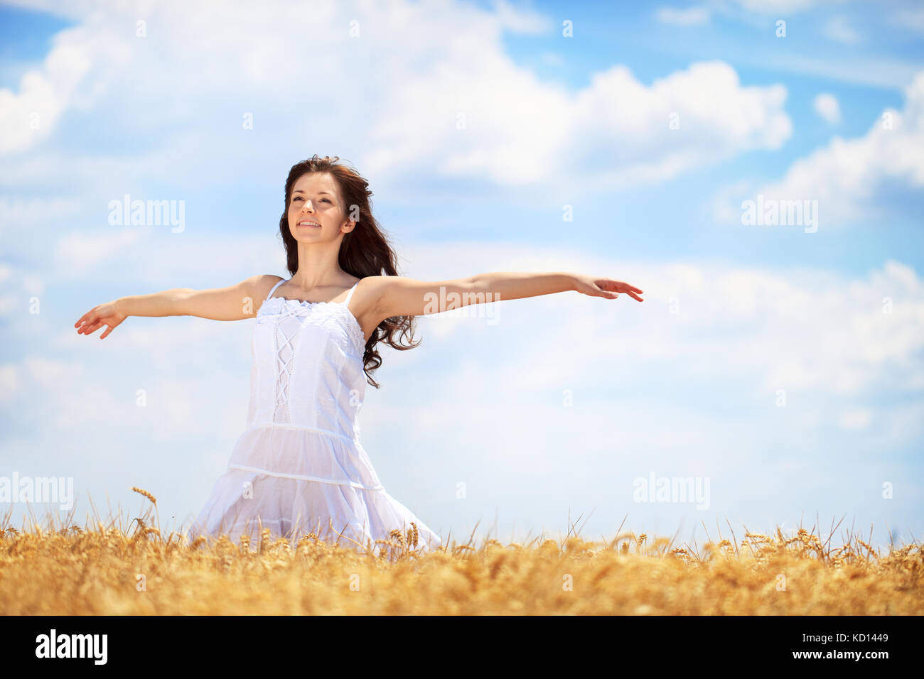 Giovane donna con gioia in golden campo di grano Foto Stock