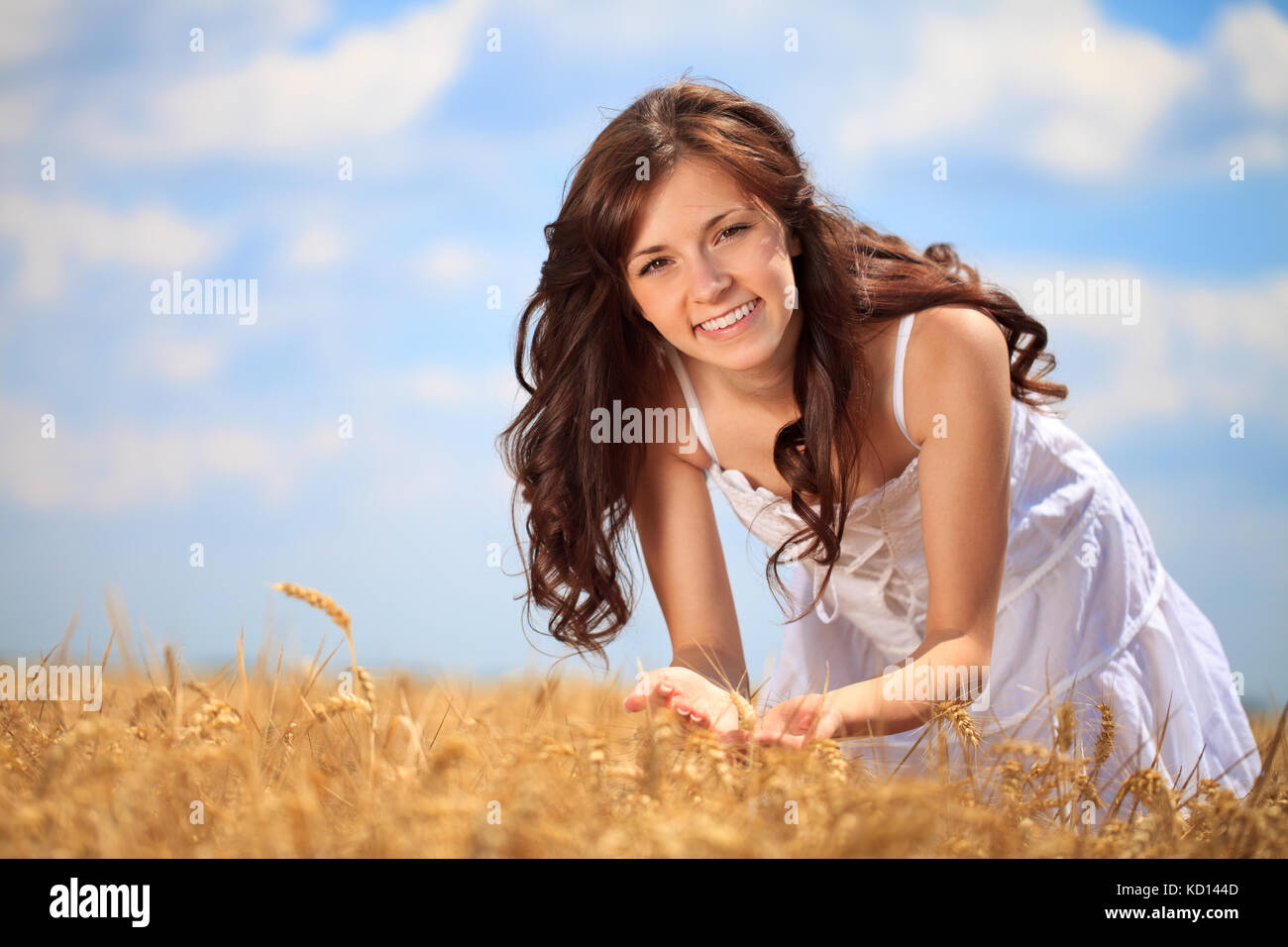 Ragazza carina nel campo di grano di godere in estate Foto Stock