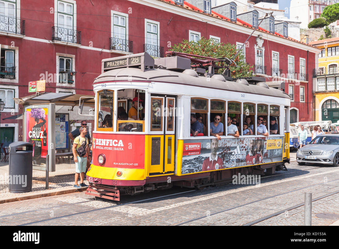 Lisbona, Portogallo - 13 agosto 2017: Il tram rosso e giallo corre lungo la strada, la gente comune e i turisti camminano nelle vicinanze Foto Stock