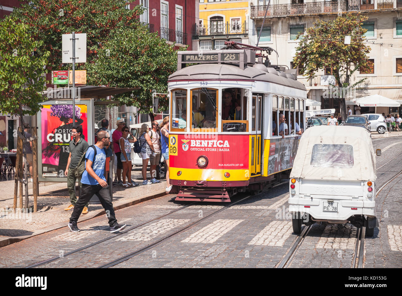 Lisbona, Portogallo - 13 agosto 2017: Il tram rosso e giallo corre lungo la strada della vecchia Lisbona, la gente comune e i turisti camminano nelle vicinanze Foto Stock