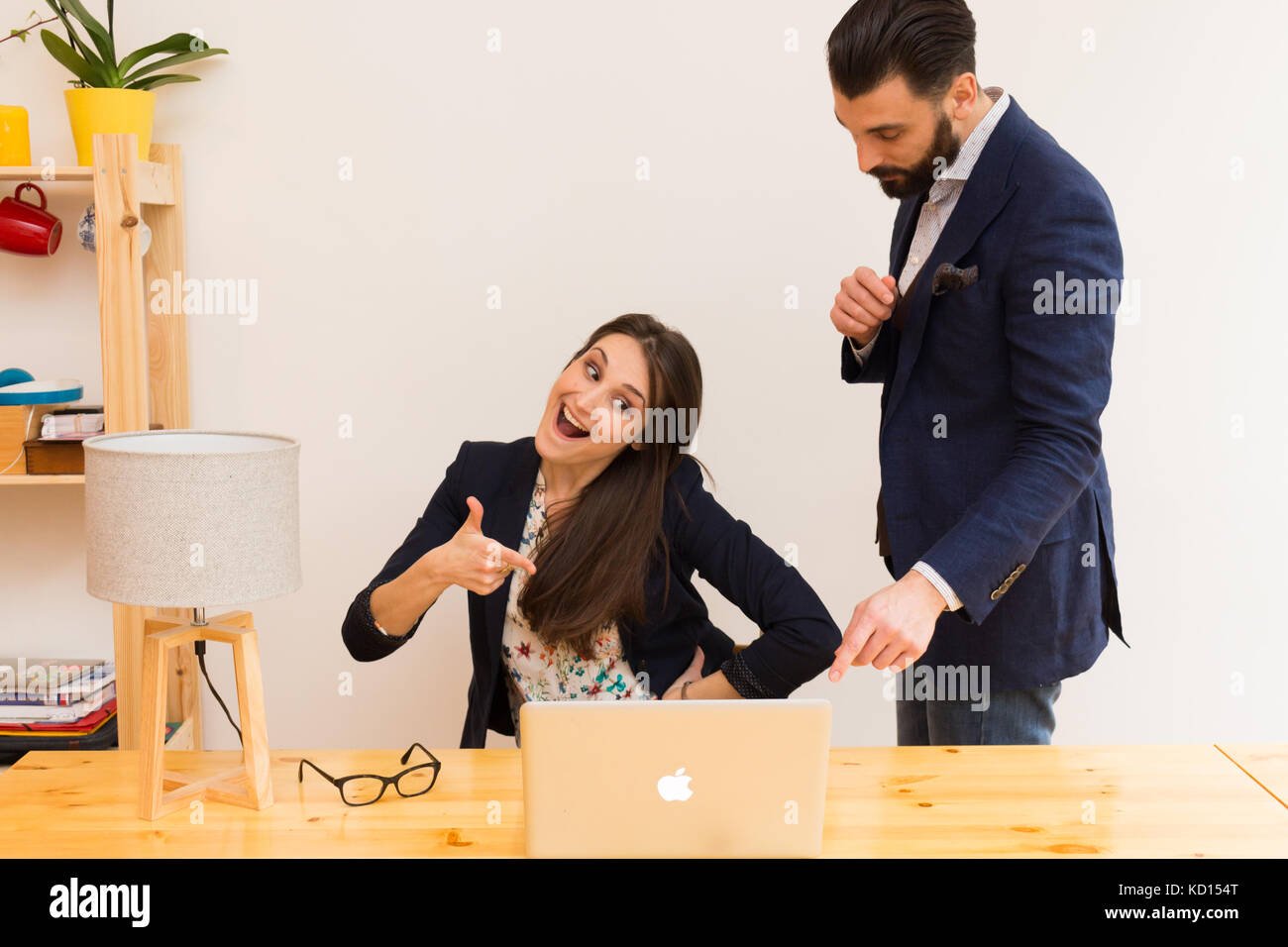 I colleghi in ufficio a lavorare insieme su laptop Foto Stock