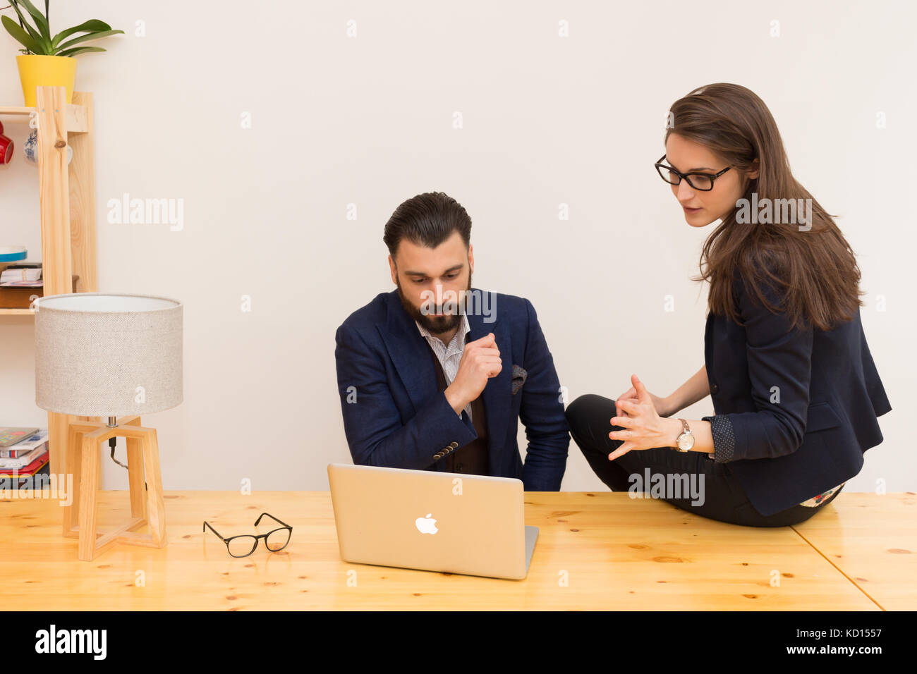 I colleghi in ufficio a lavorare insieme su laptop Foto Stock