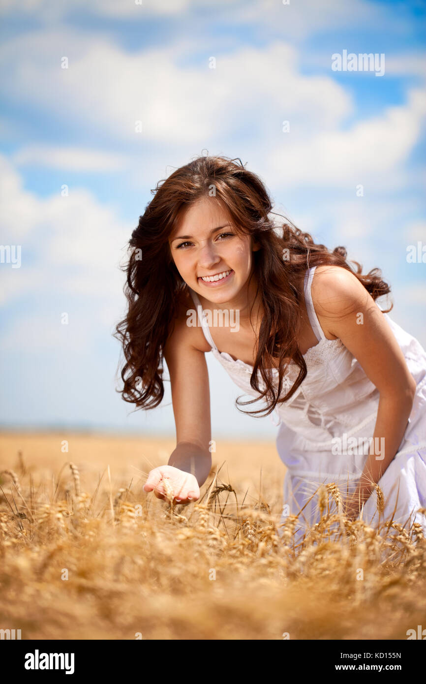 Giovane donna sorridente in golden campo di grano Foto Stock