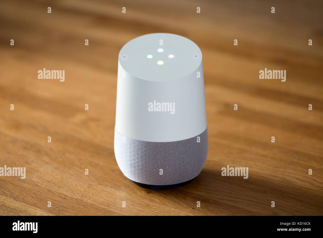 Il rilascio 2016 Home page di Google smart speaker e intelligente assistente personale dispositivo sparato contro un sfondo di legno (solo uso editoriale). Foto Stock