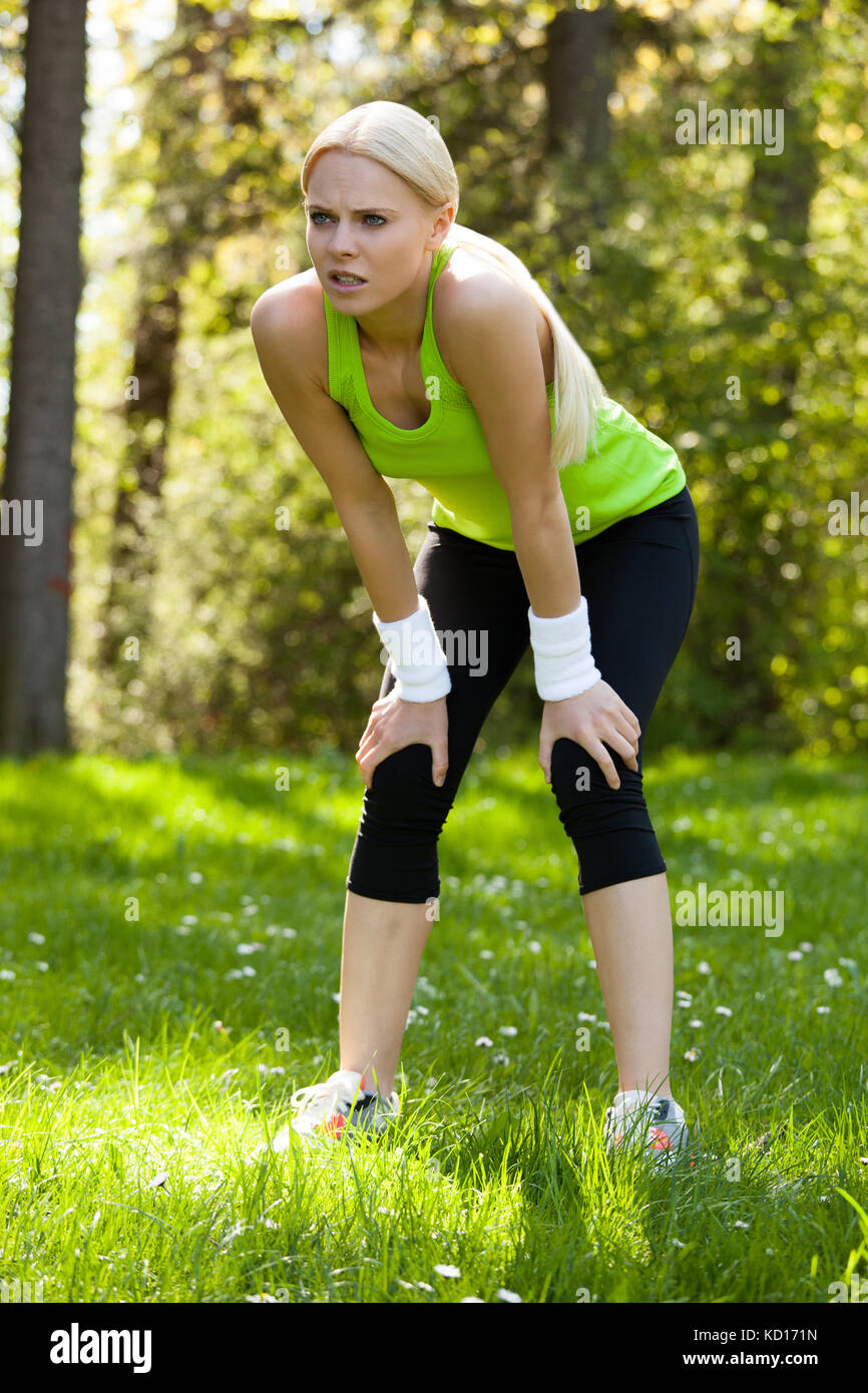 Foto di giovane donna esausta che si rilassa dopo l'allenamento Foto Stock