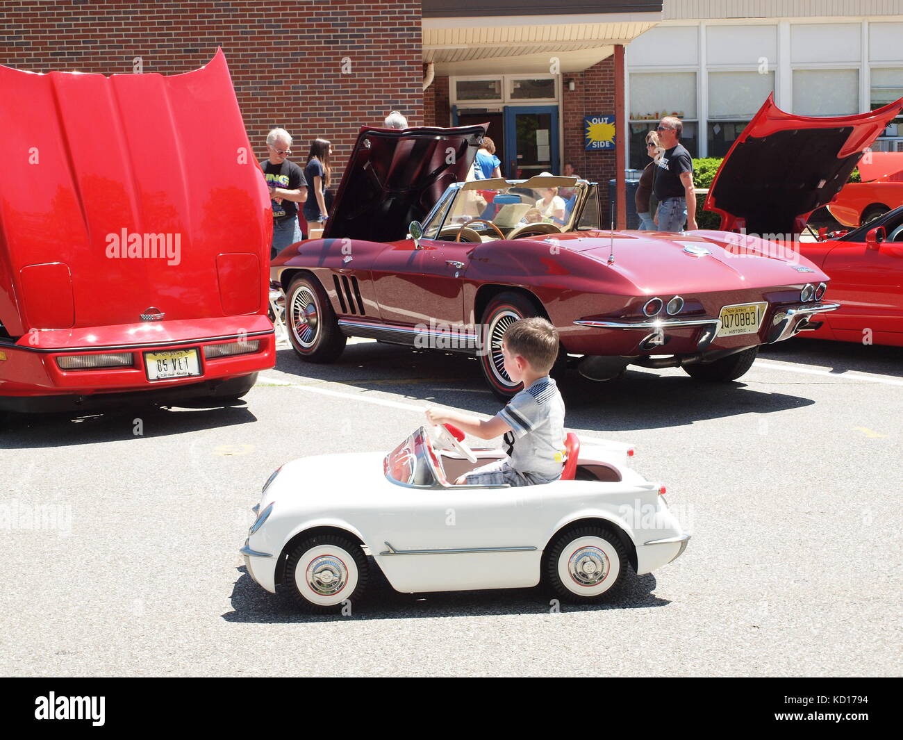 Ragazzino con Corvette auto pedale sognando che forse si otterrà un vero Vette. Visto presso il locale car show Foto Stock