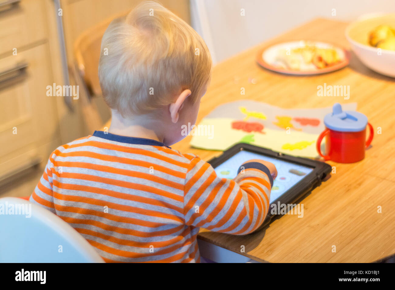 Bambino usando un tablet touch-screen per giocare il gioco didattico Foto Stock