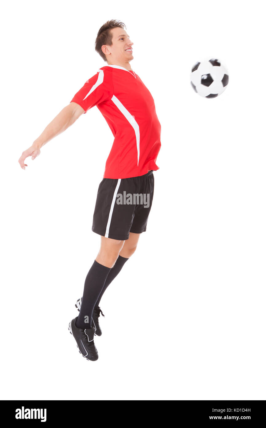 Calciatore professionista calciare la palla. Isolato su bianco Foto Stock