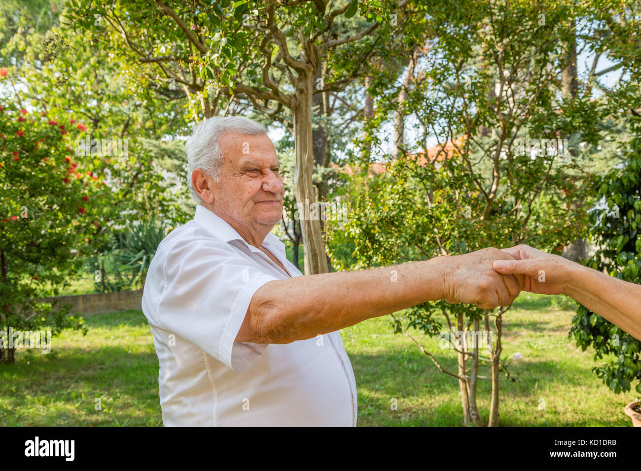 Old man mano tremante nel giardino verde Foto Stock