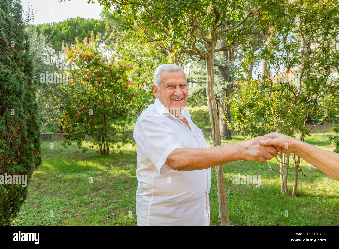 Old man mano tremante nel giardino verde Foto Stock
