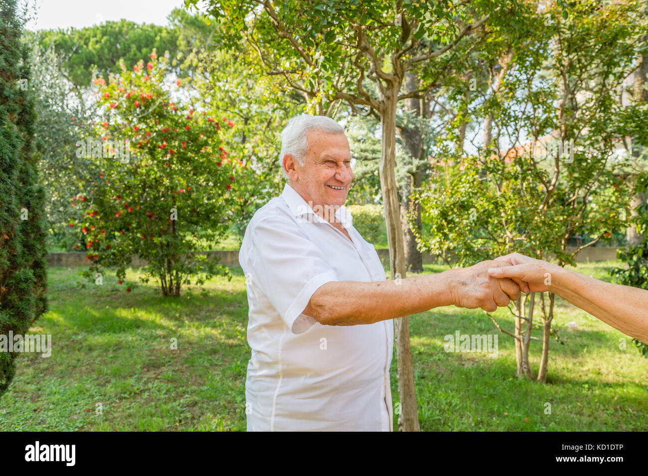 Old man mano tremante nel giardino verde Foto Stock