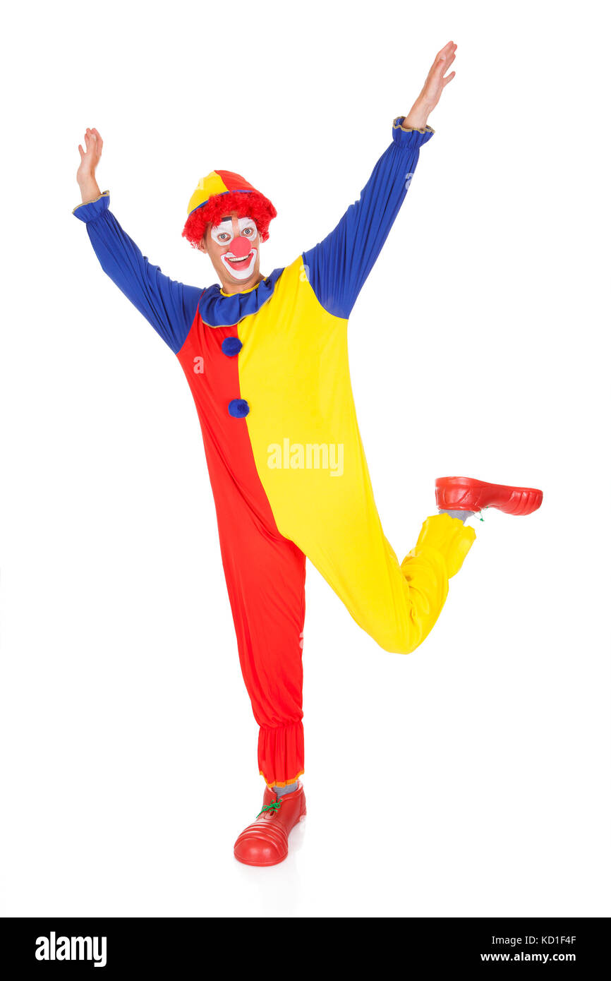 Ritratto di un felice Joker Jumping in gioia con la mano alzata Foto Stock
