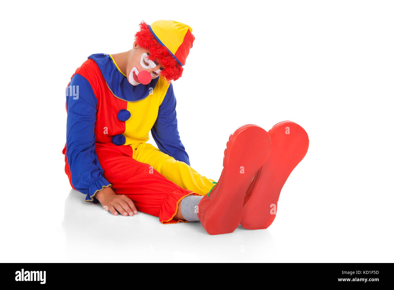 Ritratto di un clown stanchi giacente sulla parte anteriore su sfondo bianco Foto Stock