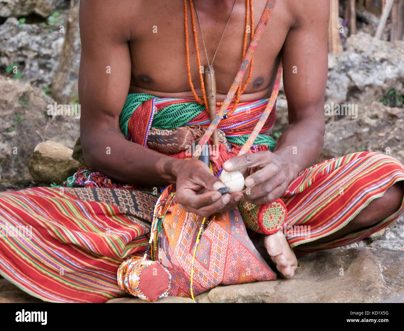 Guerriero di ex headhunting nessuna tribù, Timor Ovest, Indonesia in tessuti a mano ikat mostrando i vestiti e bordato di betel dado titolari uovo di contenimento per predire la vittoria Foto Stock Guerriero di ex headhunting nessuna tribù, Timor Ovest, Indonesia in tessuti a mano ikat mostrando i vestiti e bordato di betel dado titolari uovo di contenimento per predire la vittoria Foto Stock