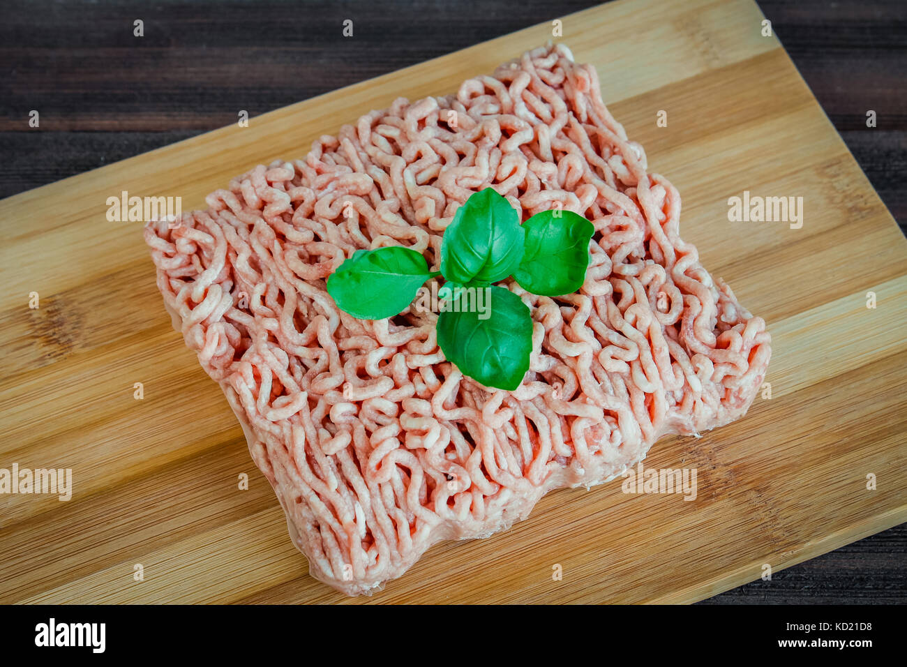 Carni macinate su uno sfondo di legno. Foto Stock